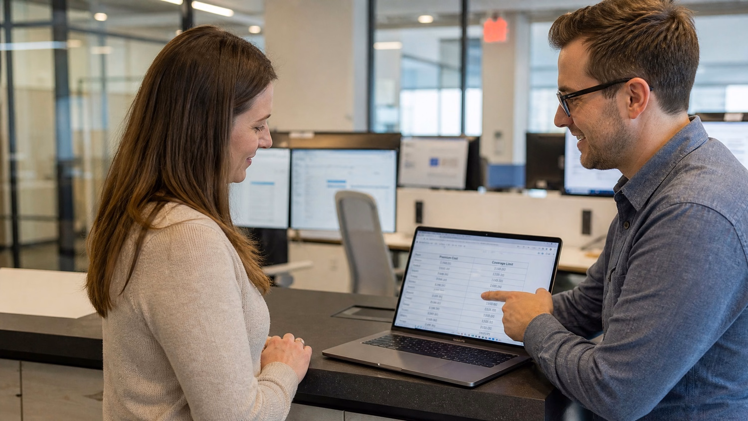 Colleagues discuss spreadsheet on laptop counter during coffee break 70