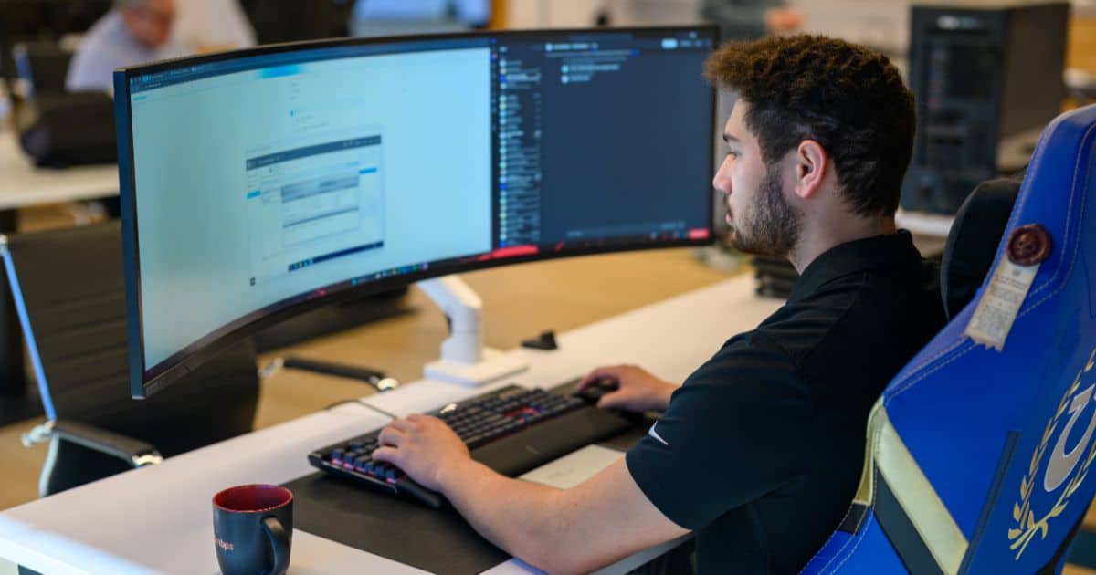 MBPS engineer reviewing data dashboards on an ultrawide monitor