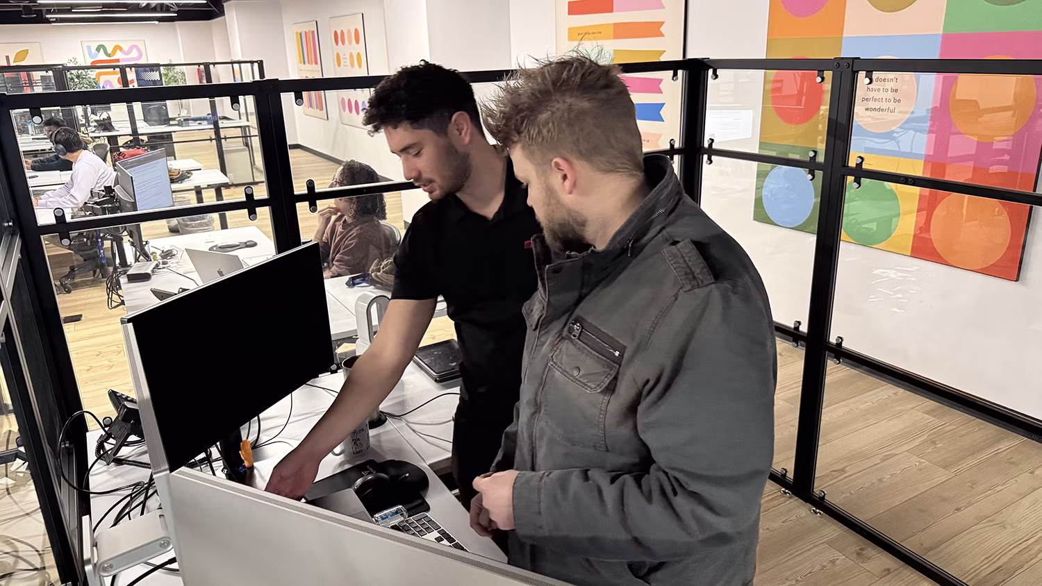 MBPS engineers reviewing a screen together in the open office