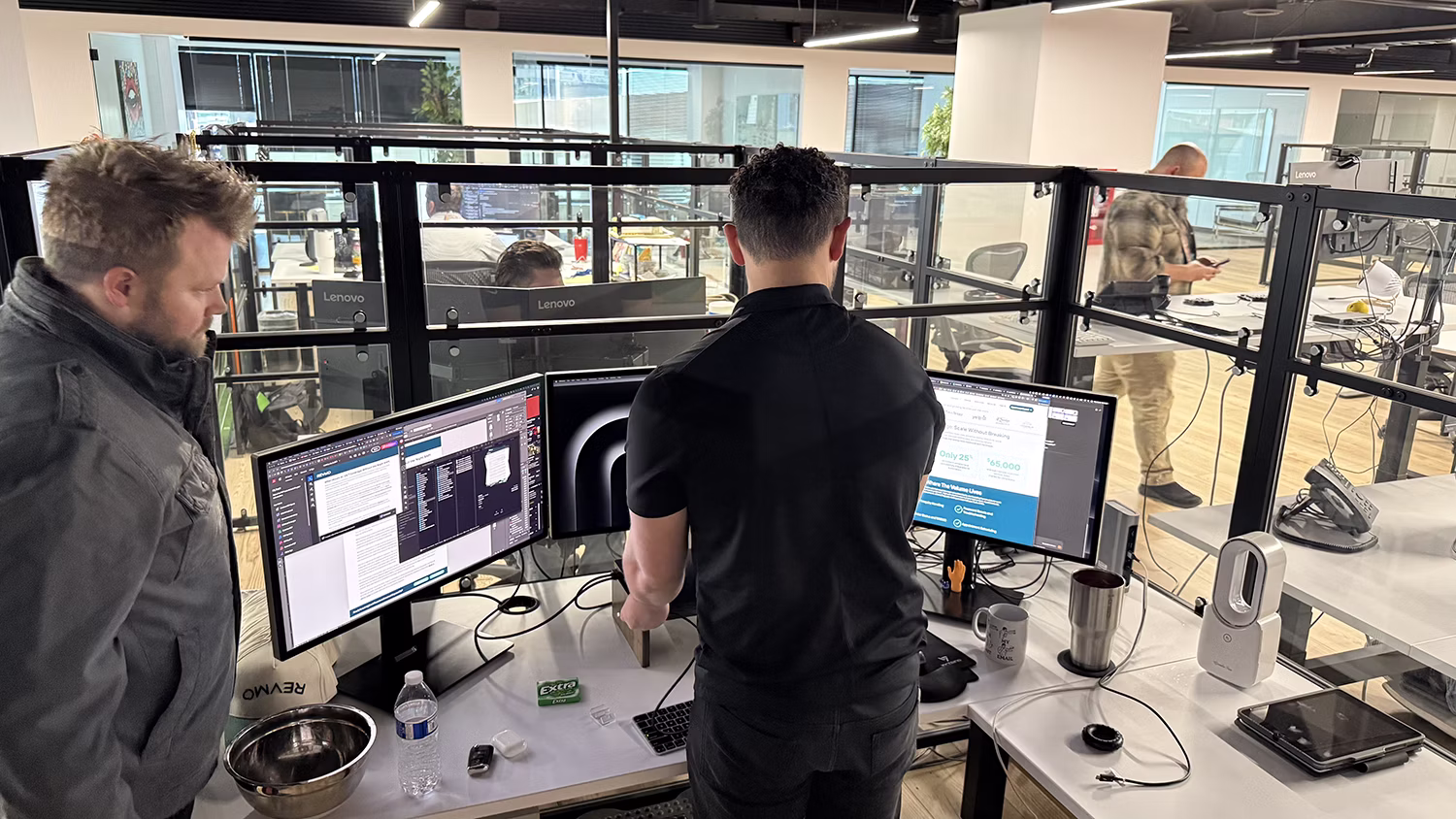 MBPS engineers working at standing desks with dual monitors