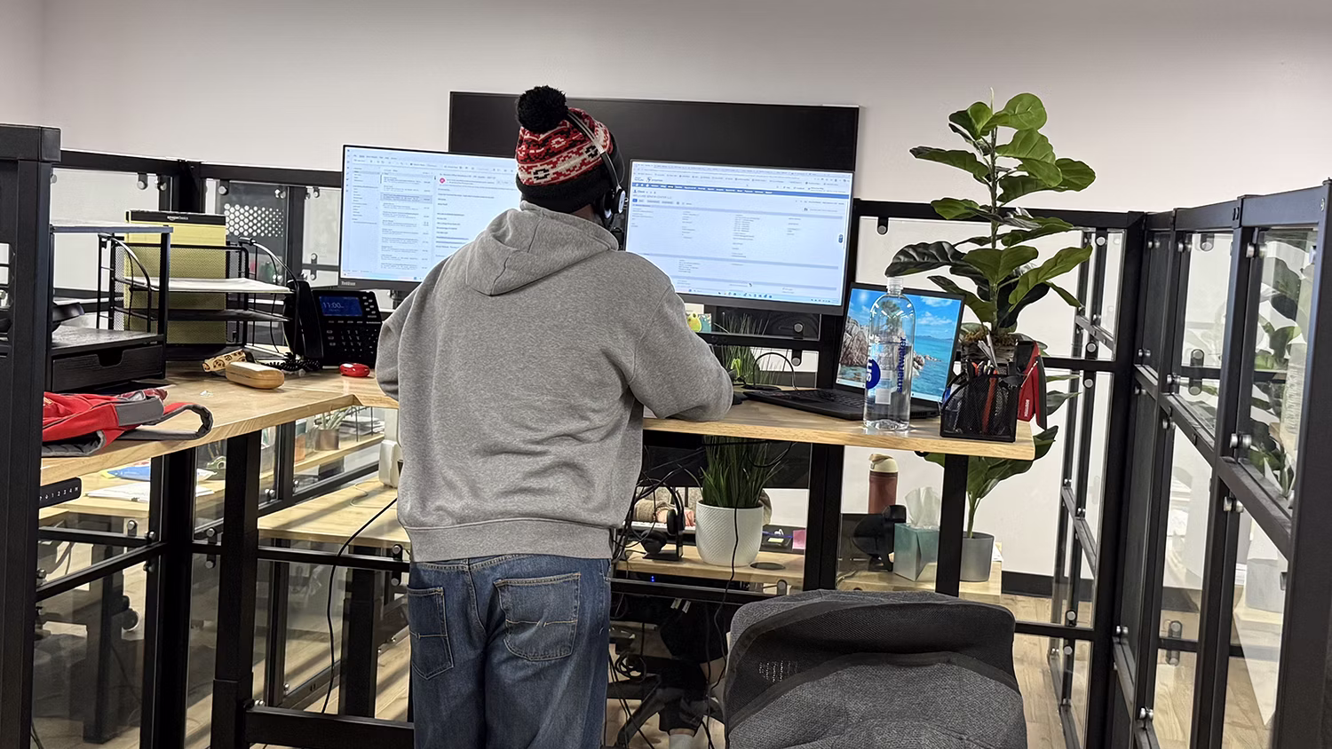 MBPS employee working at a standing desk with dual monitors