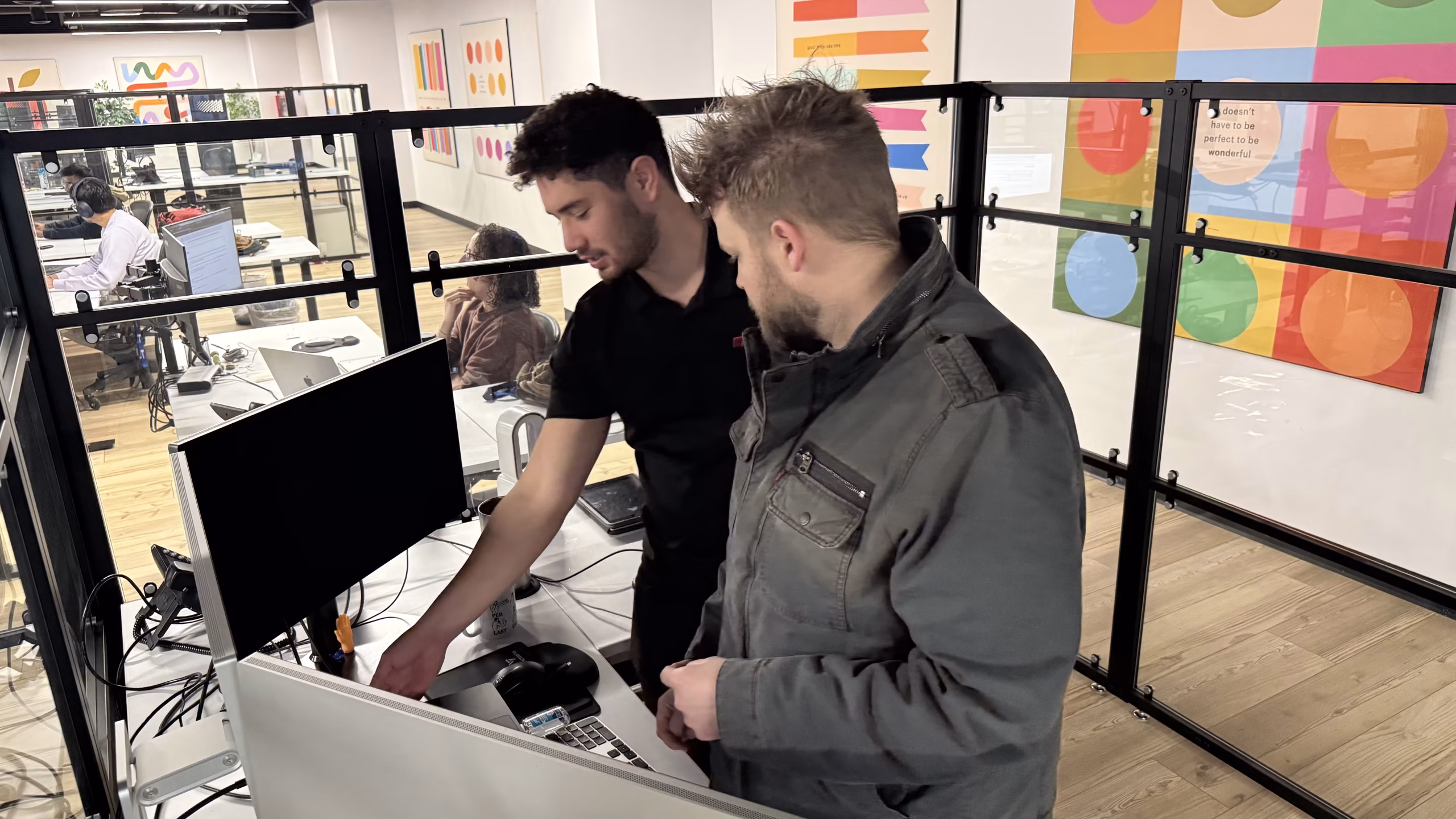 Two MBPS engineers troubleshooting together at a desk workstation