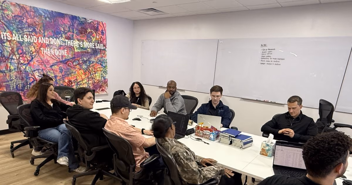 MBPS team meeting beneath a colorful mural in the office