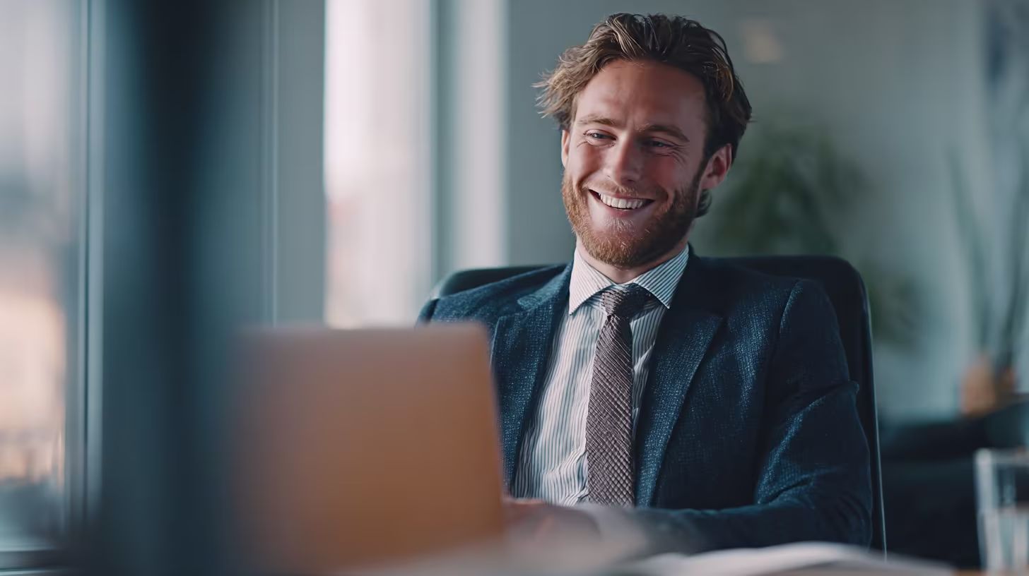 Businessman smiling while working at a laptop