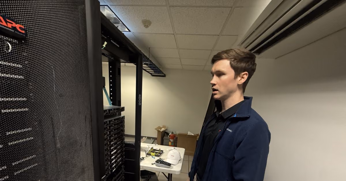 MBPS engineer standing beside a server rack