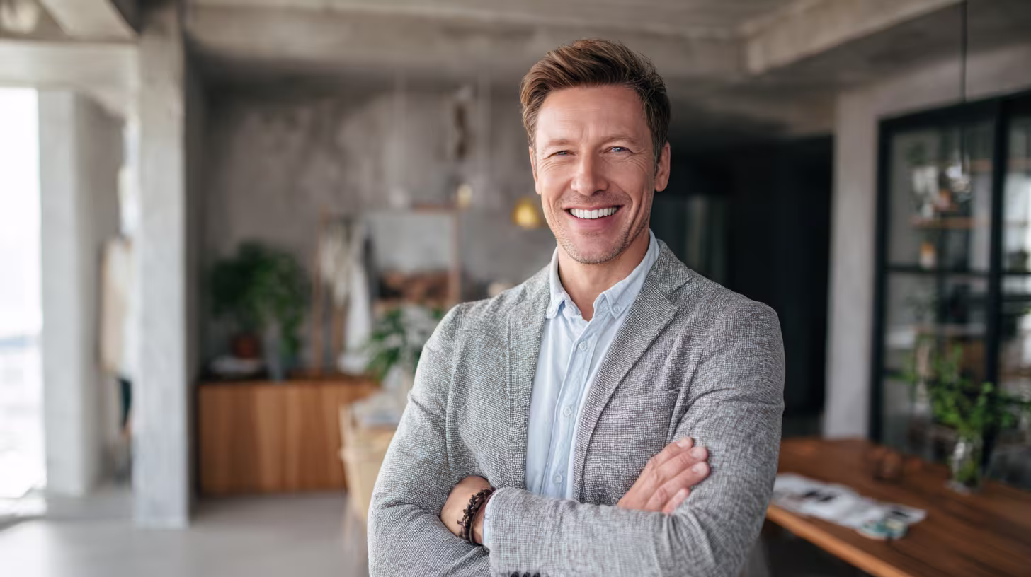Businessman standing with arms folded in a modern office
