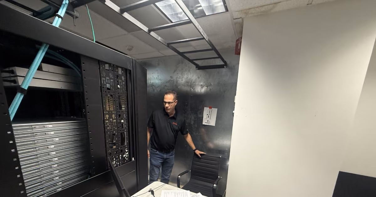 MBPS technician beside server racks in an equipment room