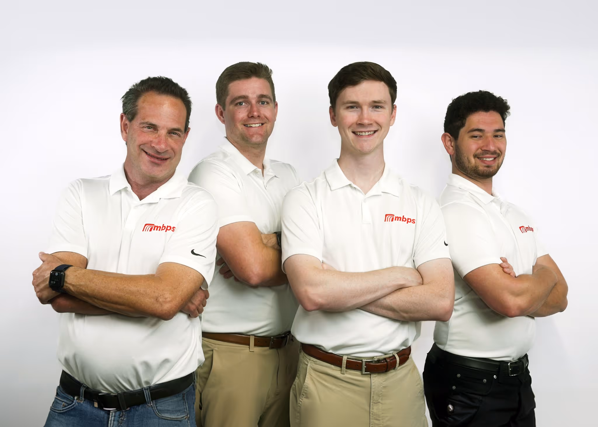 Four MBPS team members in white polos standing together