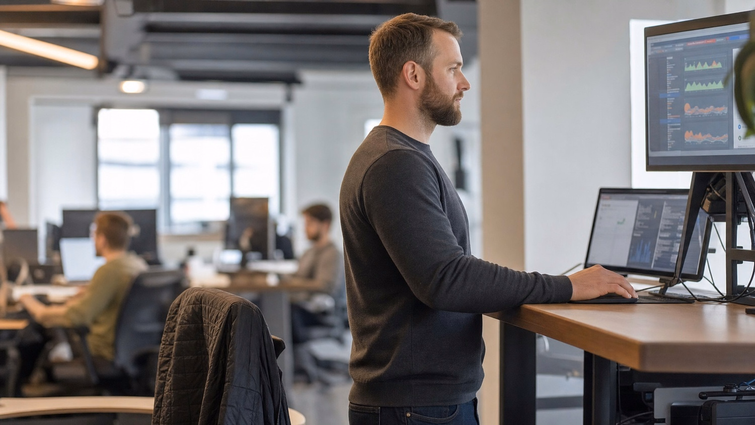 IT professional at standing desk, reviewing computer screen