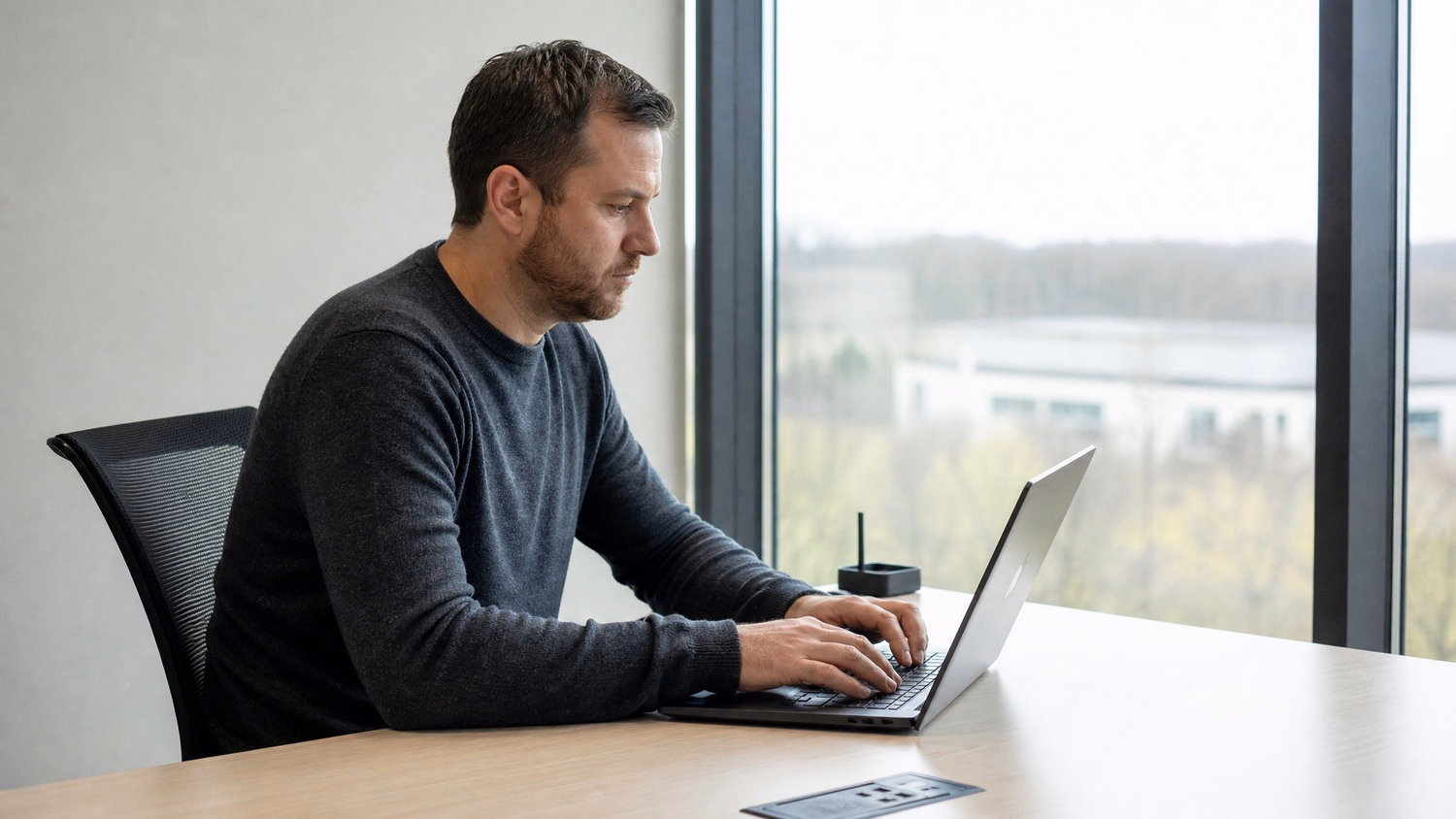 WINDOW SEAT LAPTOP An IT professional one person working on a laptop at a de