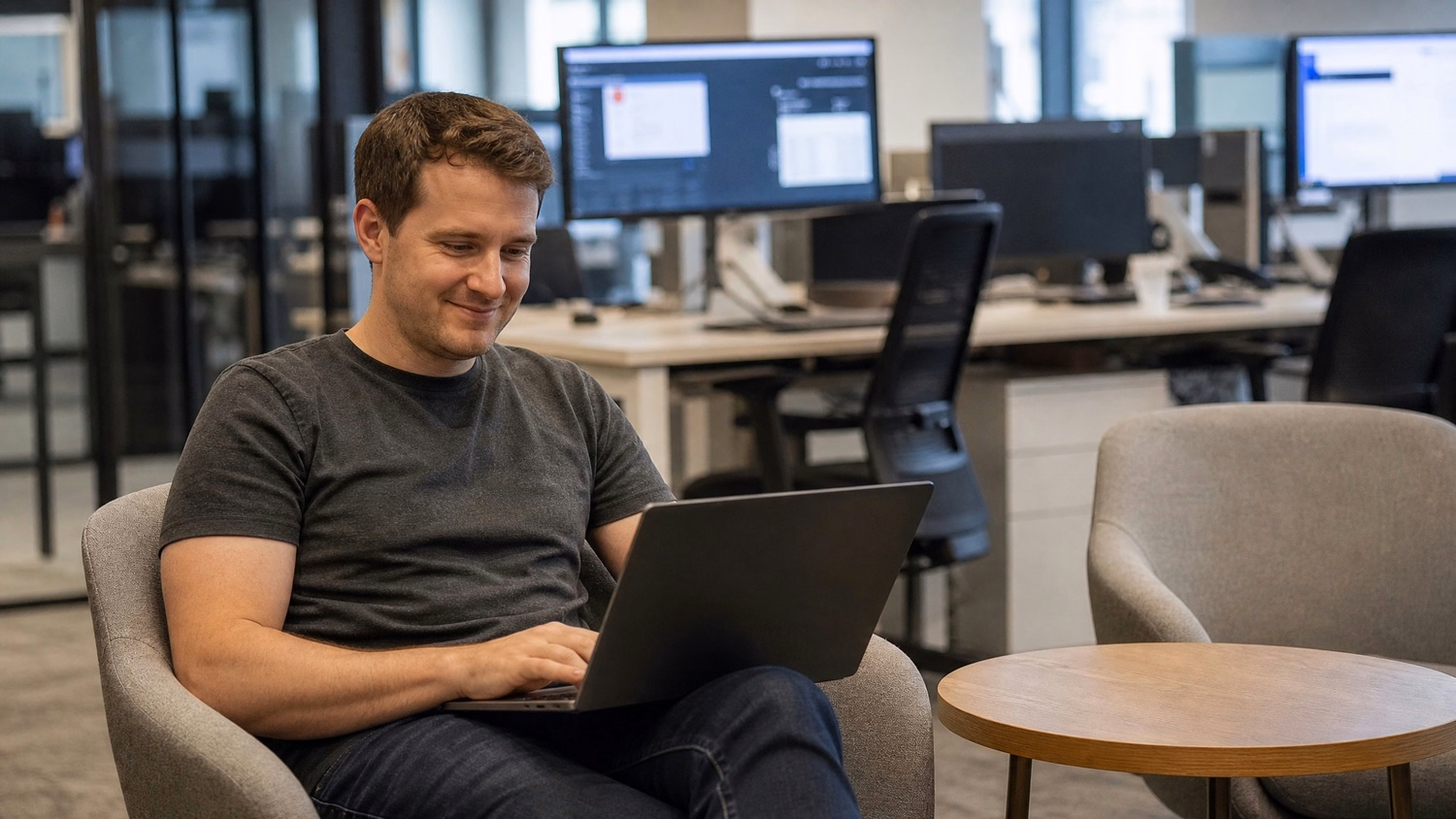 Employee working remotely on laptop in modern lounge area 64 chars